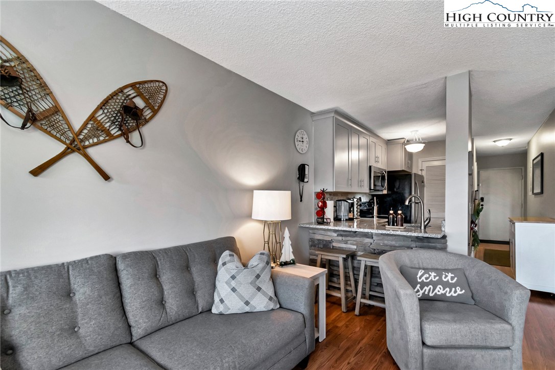 301 Pinnacle Inn Road, Unit 1215 Banner Elk, NC 28604 - Photo 16 of 47 a living room with furniture and a wooden floor