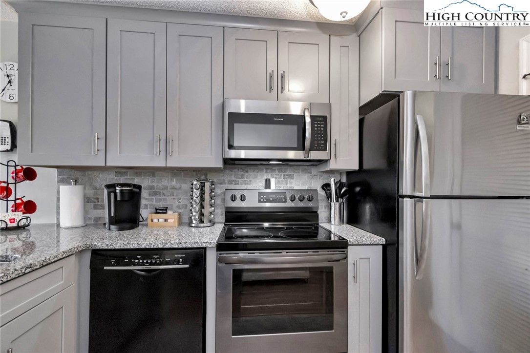 301 Pinnacle Inn Road, Unit 1215 Banner Elk, NC 28604 - Photo 19 of 47 a kitchen with refrigerator a stove and cabinets