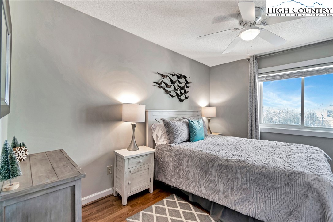 301 Pinnacle Inn Road, Unit 1215 Banner Elk, NC 28604 - Photo 22 of 47 a bedroom with a bed and a chandelier