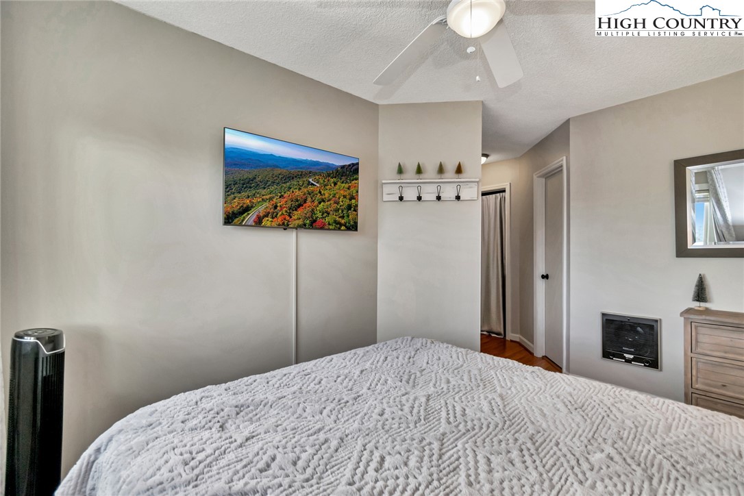 301 Pinnacle Inn Road, Unit 1215 Banner Elk, NC 28604 - Photo 24 of 47 a bedroom with a bed and a chandelier