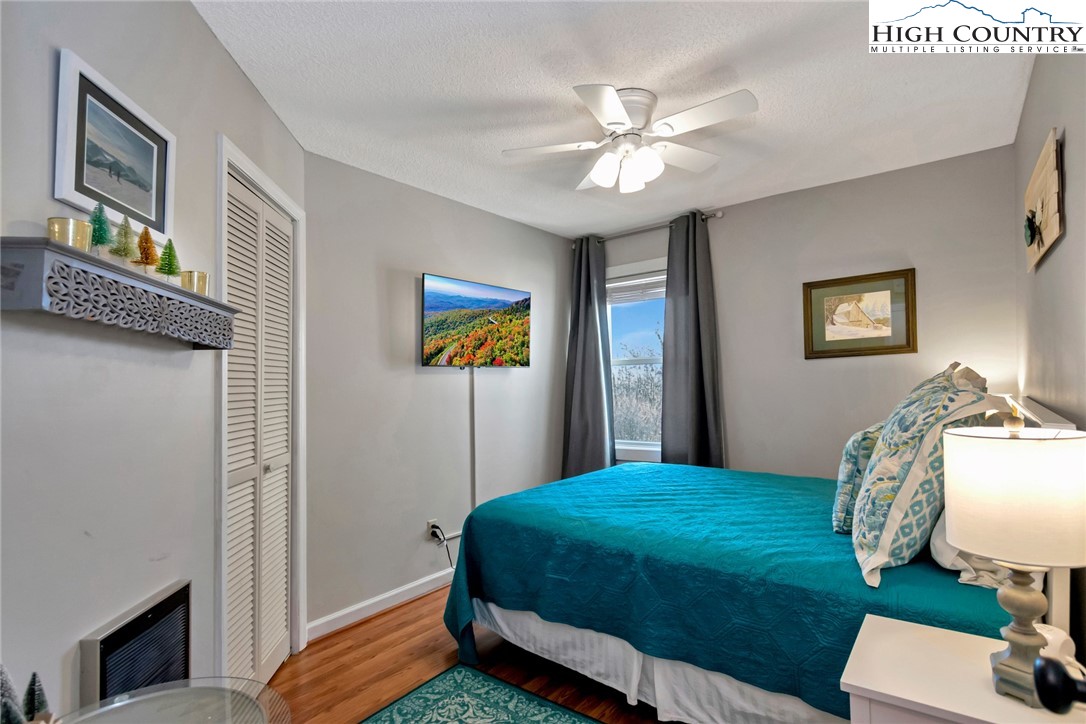 301 Pinnacle Inn Road, Unit 1215 Banner Elk, NC 28604 - Photo 27 of 47 a bedroom with a bed and a chandelier