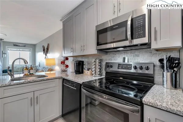 a kitchen with stainless steel appliances granite countertop a stove and a microwave