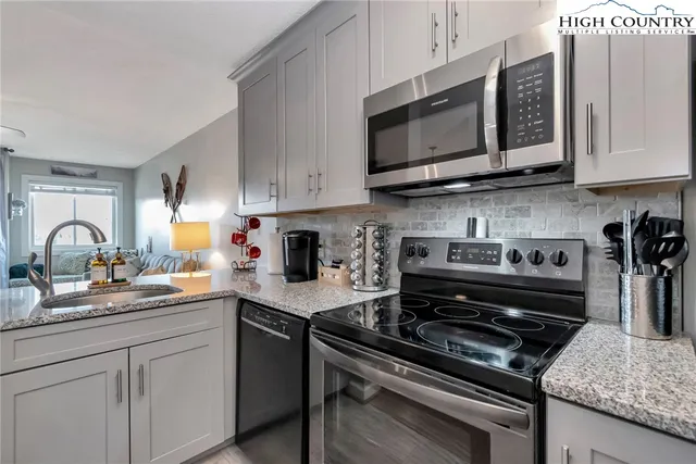 a kitchen with stainless steel appliances granite countertop a stove and a microwave