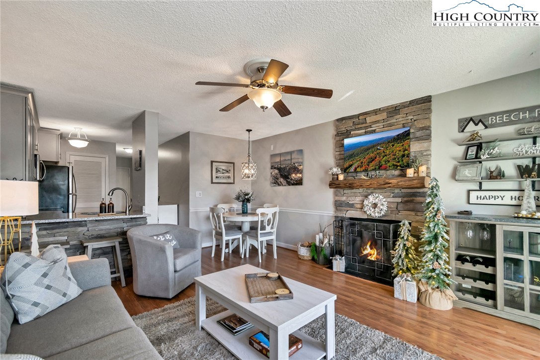 301 Pinnacle Inn Road, Unit 1215 Banner Elk, NC 28604 - Photo 31 of 47 a living room with furniture a fireplace and a flat screen tv
