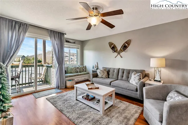 a living room with furniture and a large window with wooden floor