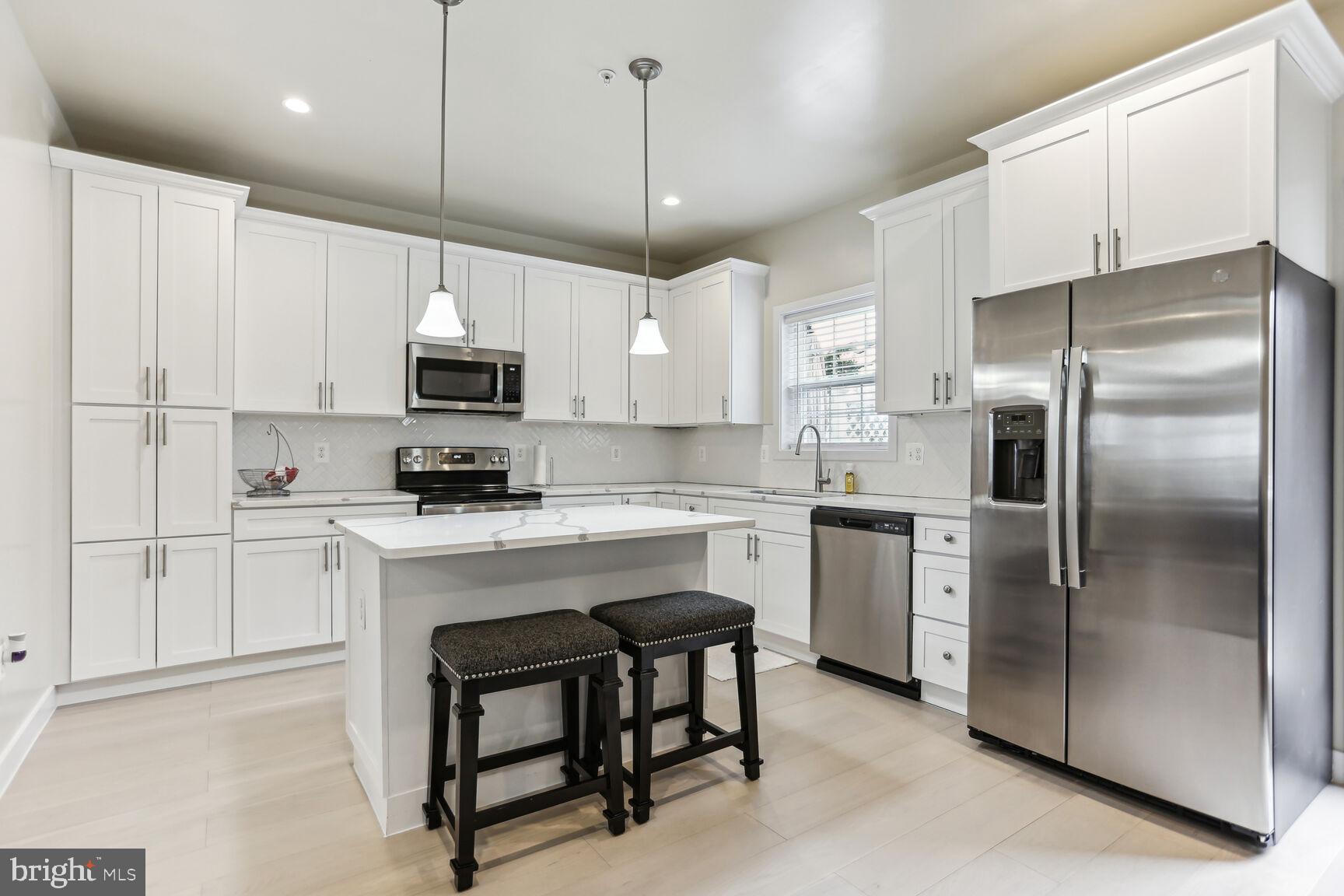 a kitchen with cabinets stainless steel appliances and a center island
