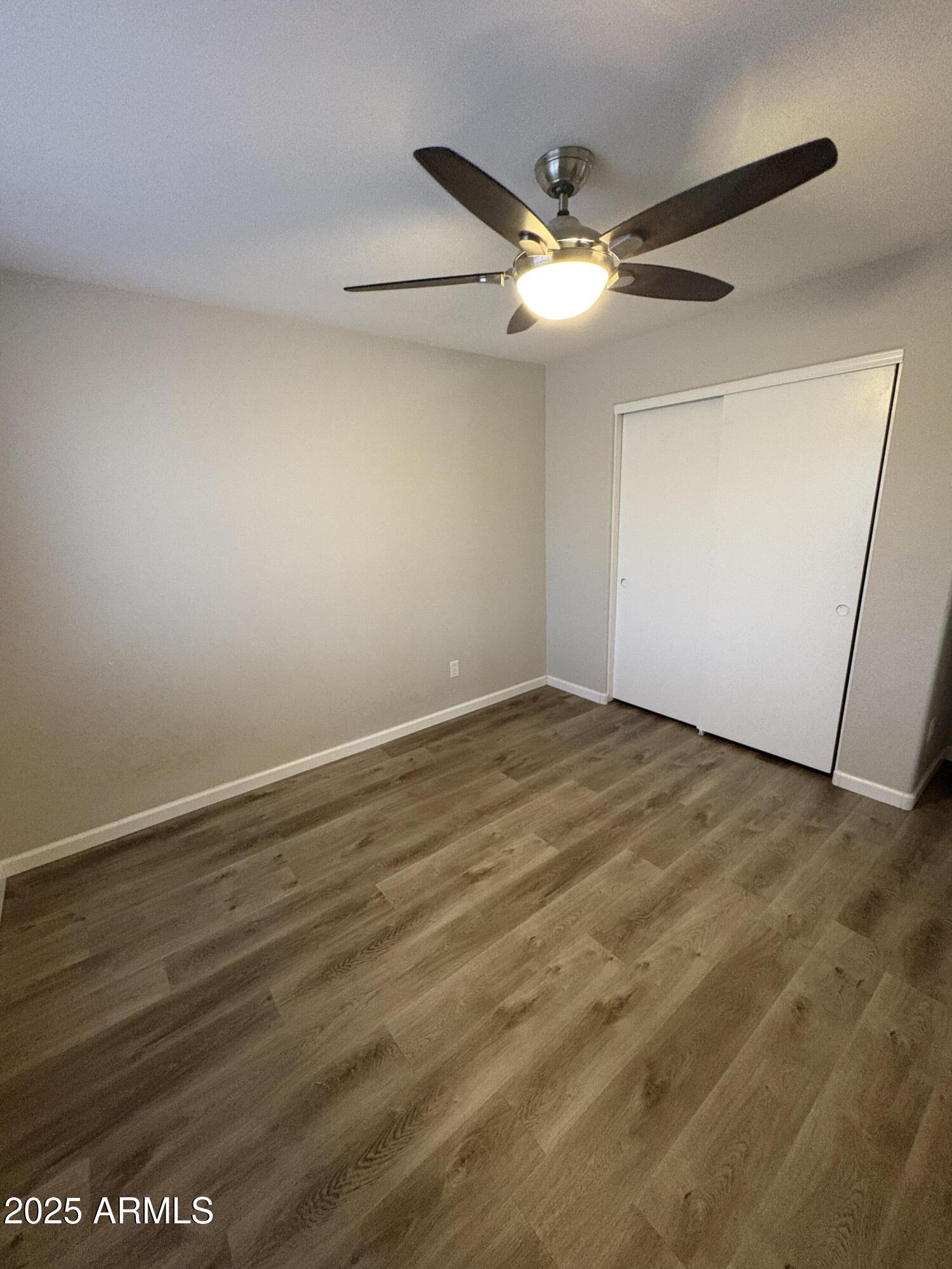 1472 East Constitution Drive Chandler, AZ 85225 - Photo 19 of 27 an empty room with wooden floor and fan