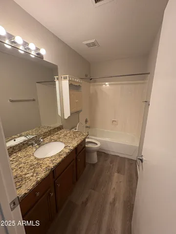 en empty room with wooden floor and fan