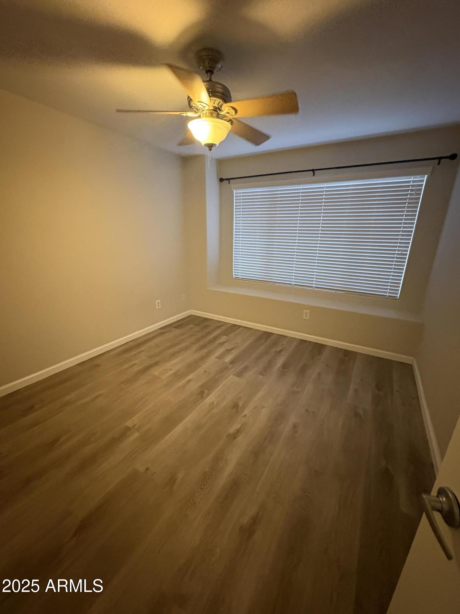 1472 East Constitution Drive Chandler, AZ 85225 - Photo 26 of 27 en empty room with wooden floor and fan