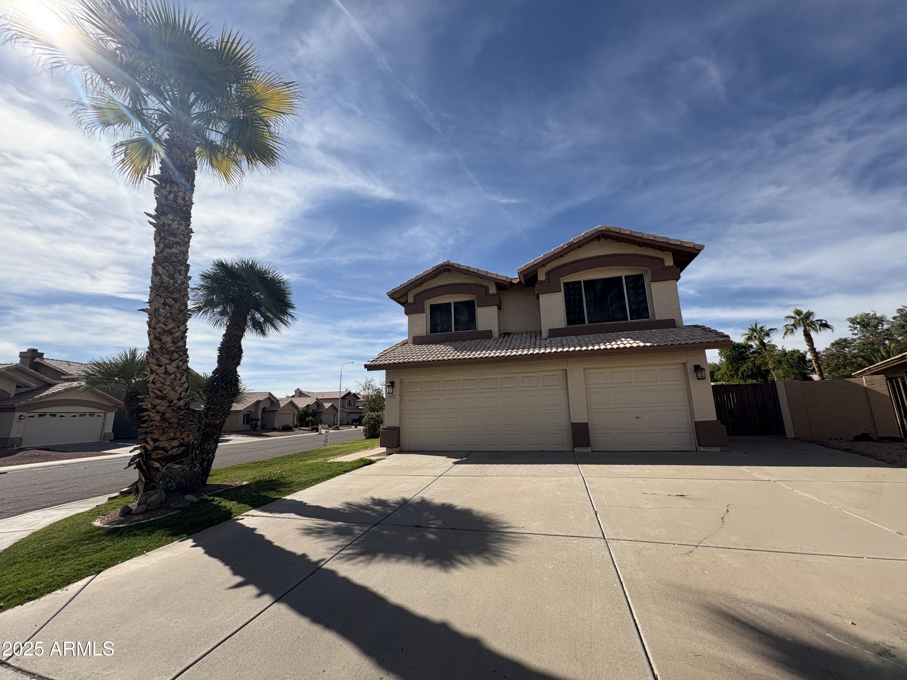 1472 East Constitution Drive Chandler, AZ 85225 - Photo 3 of 27 a front view of a house with a yard and garage