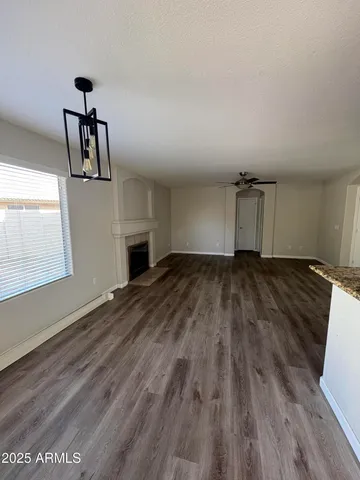 a view of empty room with wooden floor and fireplace