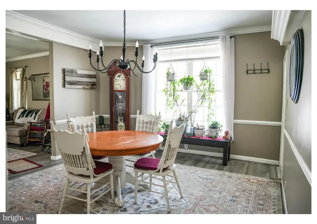 a dining room with furniture a chandelier and window