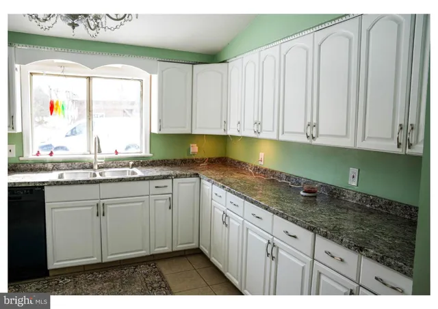 a kitchen with granite countertop a sink and cabinets
