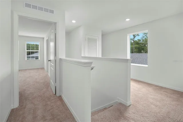 a view of a hallway with closet and bathroom