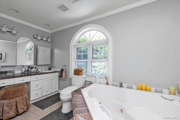 a spacious bathroom with a tub sink and mirror