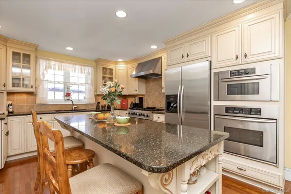 a kitchen with stainless steel appliances granite countertop a stove a sink a microwave and a refrigerator