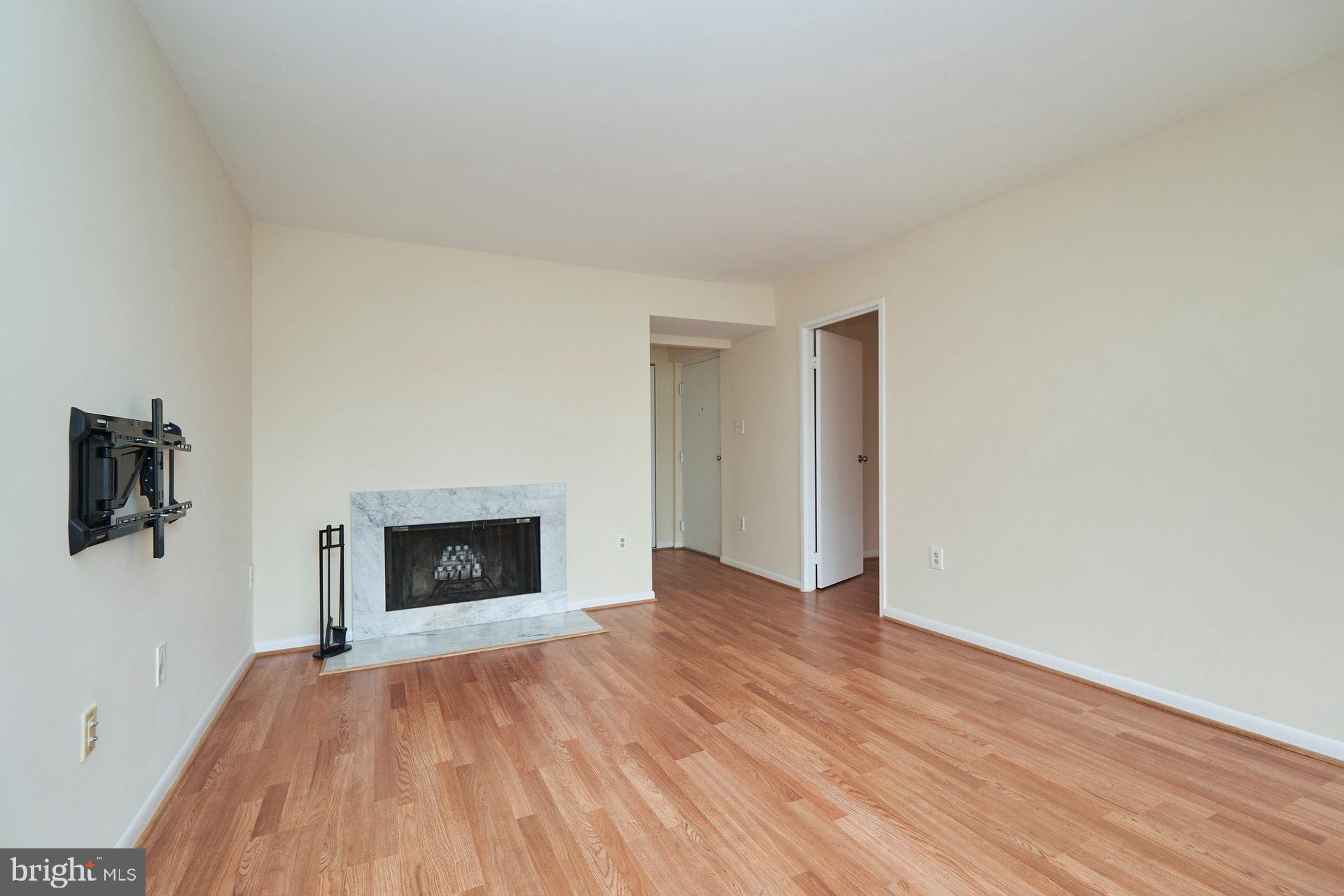 2212 Springwood Drive, Unit 206 Reston, VA 20191 - Photo 13 of 46 a view of empty room with wooden floor and fireplace