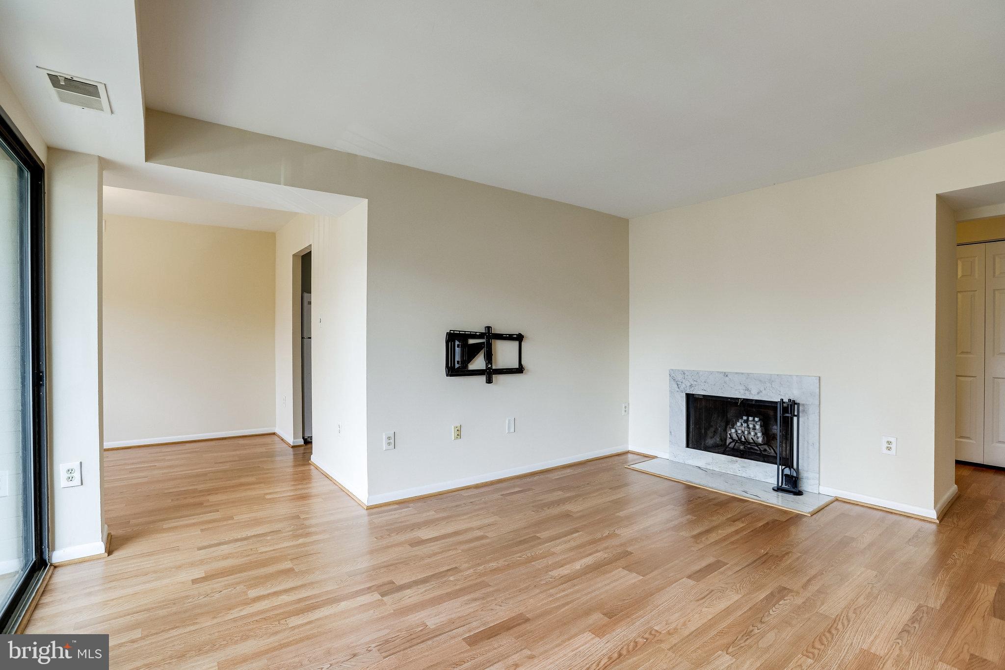 2212 Springwood Drive, Unit 206 Reston, VA 20191 - Photo 14 of 46 a view of empty room with wooden floor and fireplace