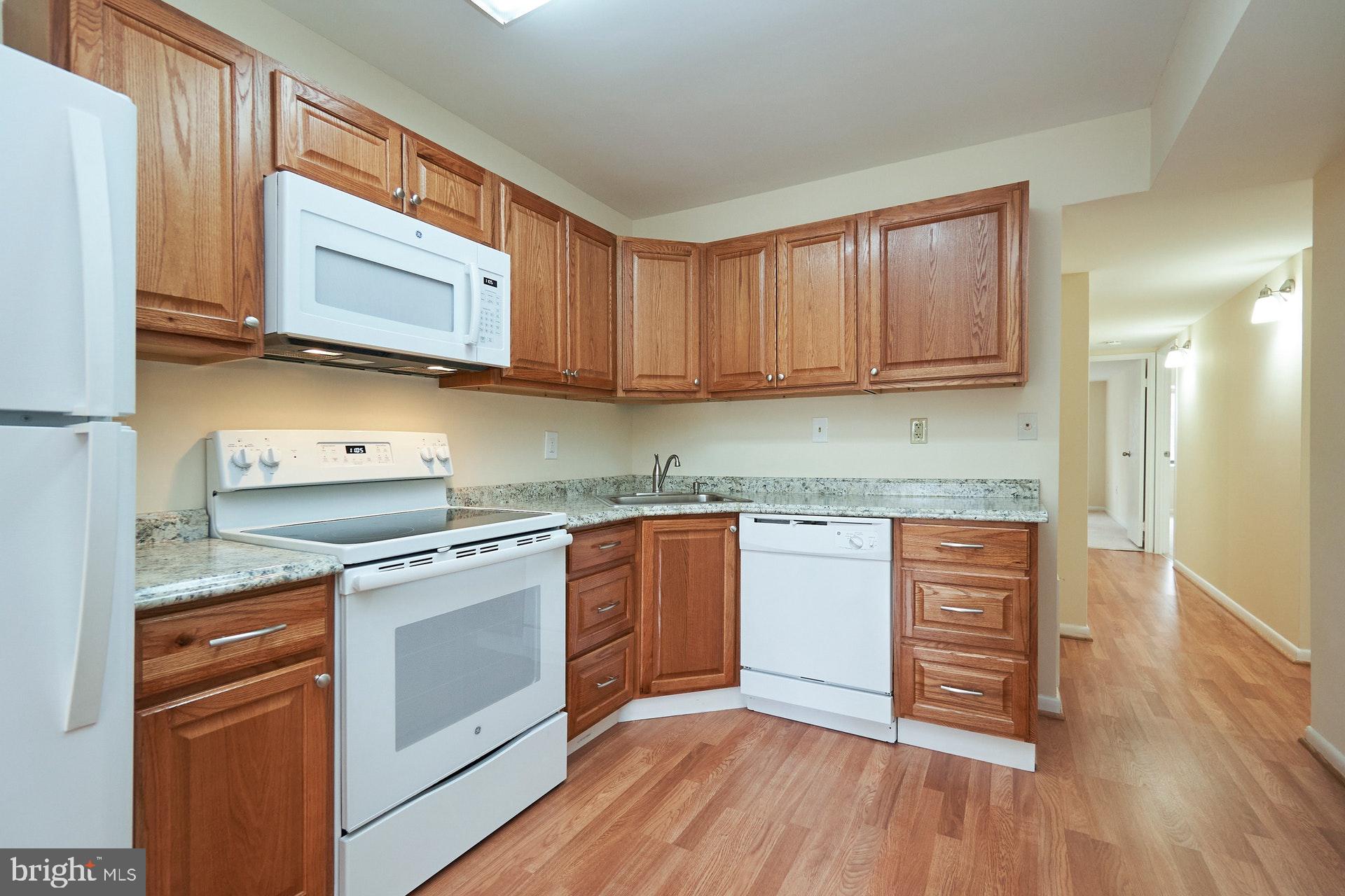 2212 Springwood Drive, Unit 206 Reston, VA 20191 - Photo 19 of 46 a kitchen with stainless steel appliances granite countertop a stove a sink and a microwave