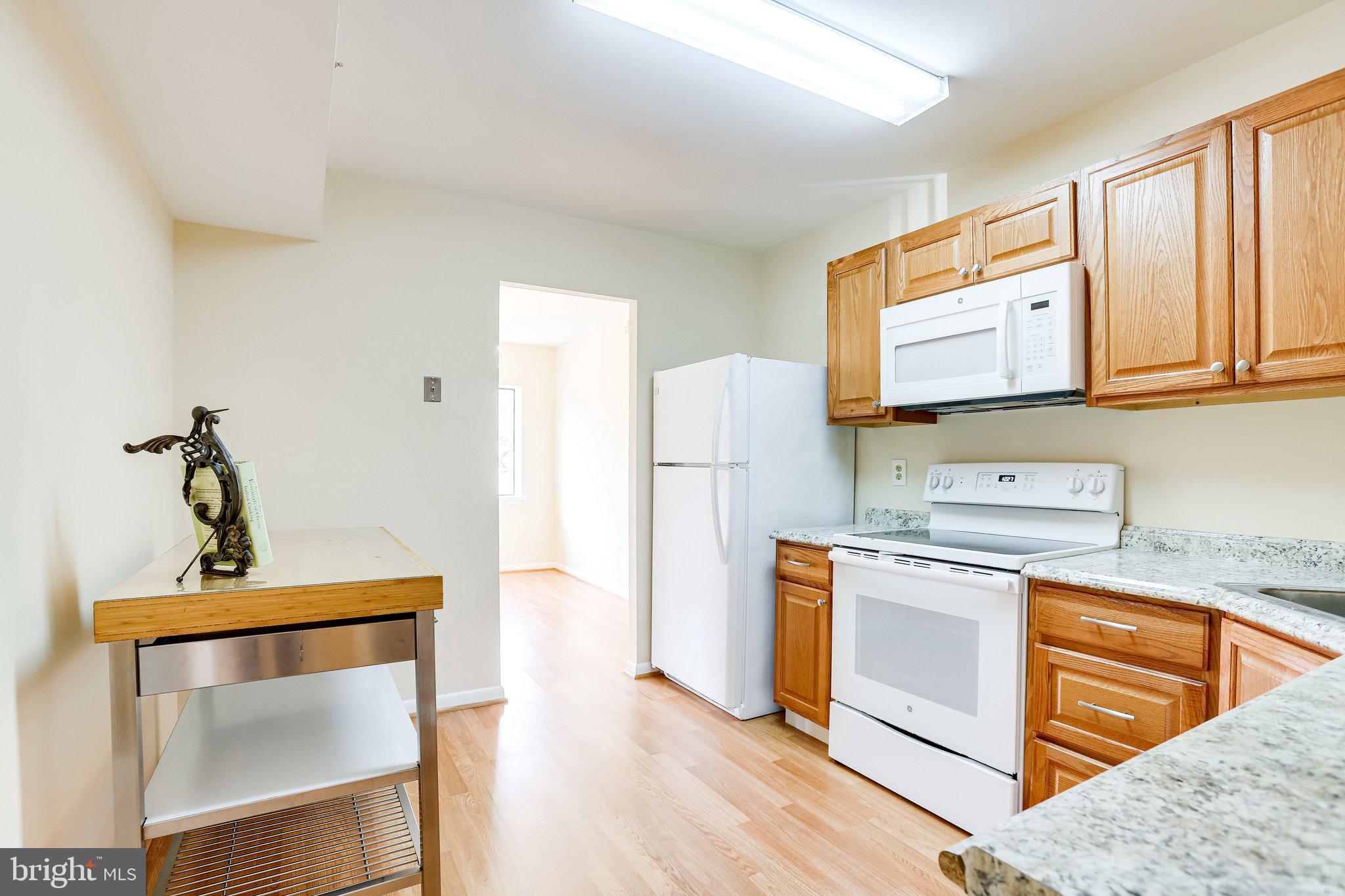 2212 Springwood Drive, Unit 206 Reston, VA 20191 - Photo 21 of 46 a kitchen with stainless steel appliances granite countertop a stove a sink and a refrigerator