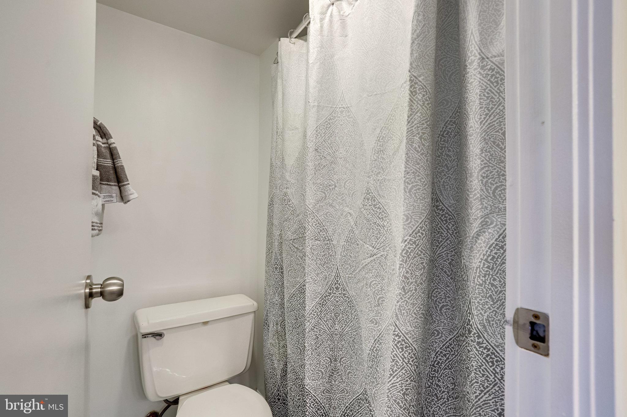 2212 Springwood Drive, Unit 206 Reston, VA 20191 - Photo 29 of 46 a white toilet sitting next to a shower curtain