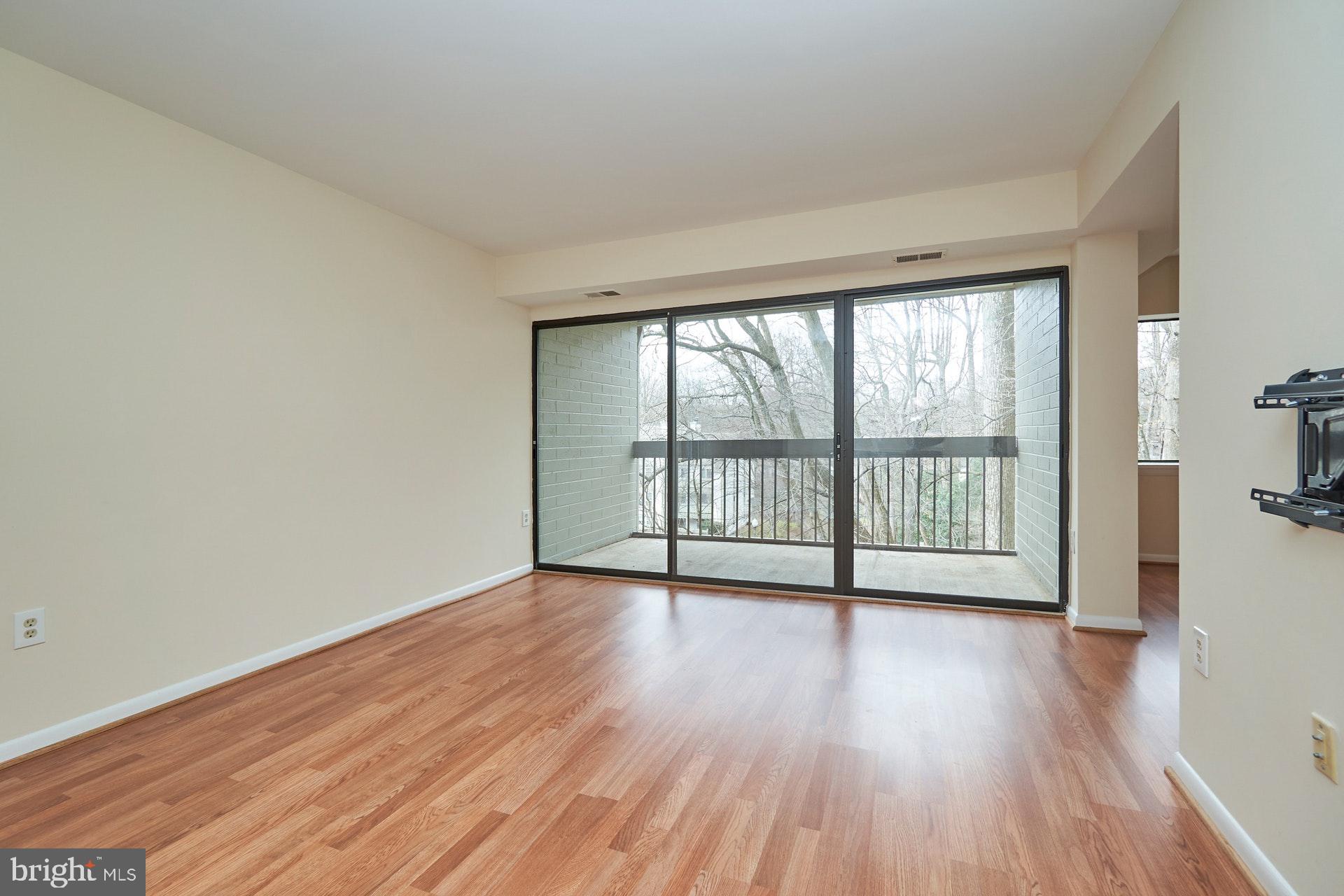 2212 Springwood Drive, Unit 206 Reston, VA 20191 - Photo 8 of 46 a view of an empty room with wooden floor and a window