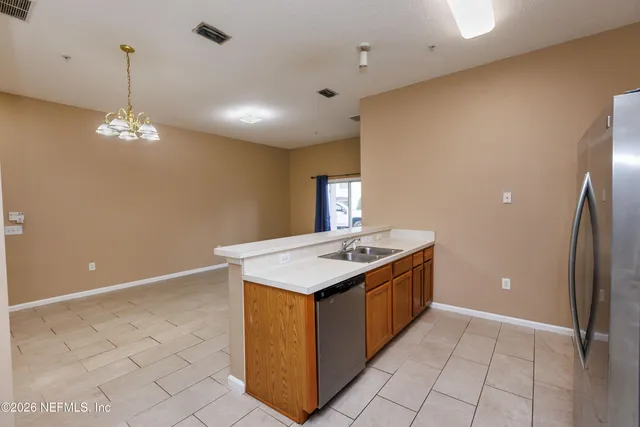 a kitchen with stainless steel appliances granite countertop a sink and a refrigerator