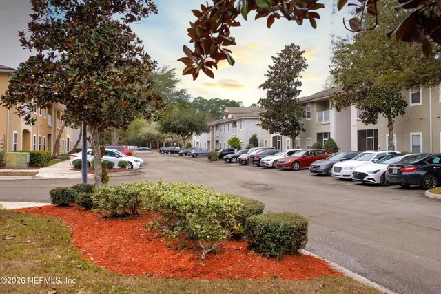 a view of a brick house with many windows and plants