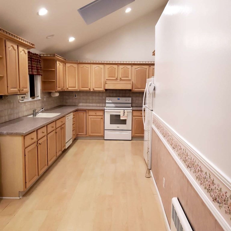 18 Davis Street Woburn, MA 01801 - Photo 12 of 20 a large kitchen with stainless steel appliances granite countertop a stove and a sink