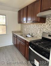 a kitchen with granite countertop a stove and a sink