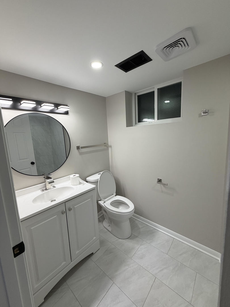 9534 South Yale Avenue Chicago, IL 60628 - Photo 12 of 26 a bathroom with a toilet sink and mirror