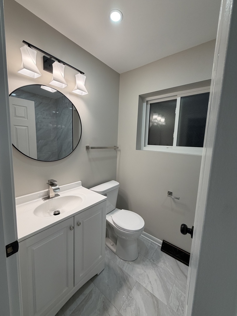 9534 South Yale Avenue Chicago, IL 60628 - Photo 13 of 26 a bathroom with a toilet sink and mirror