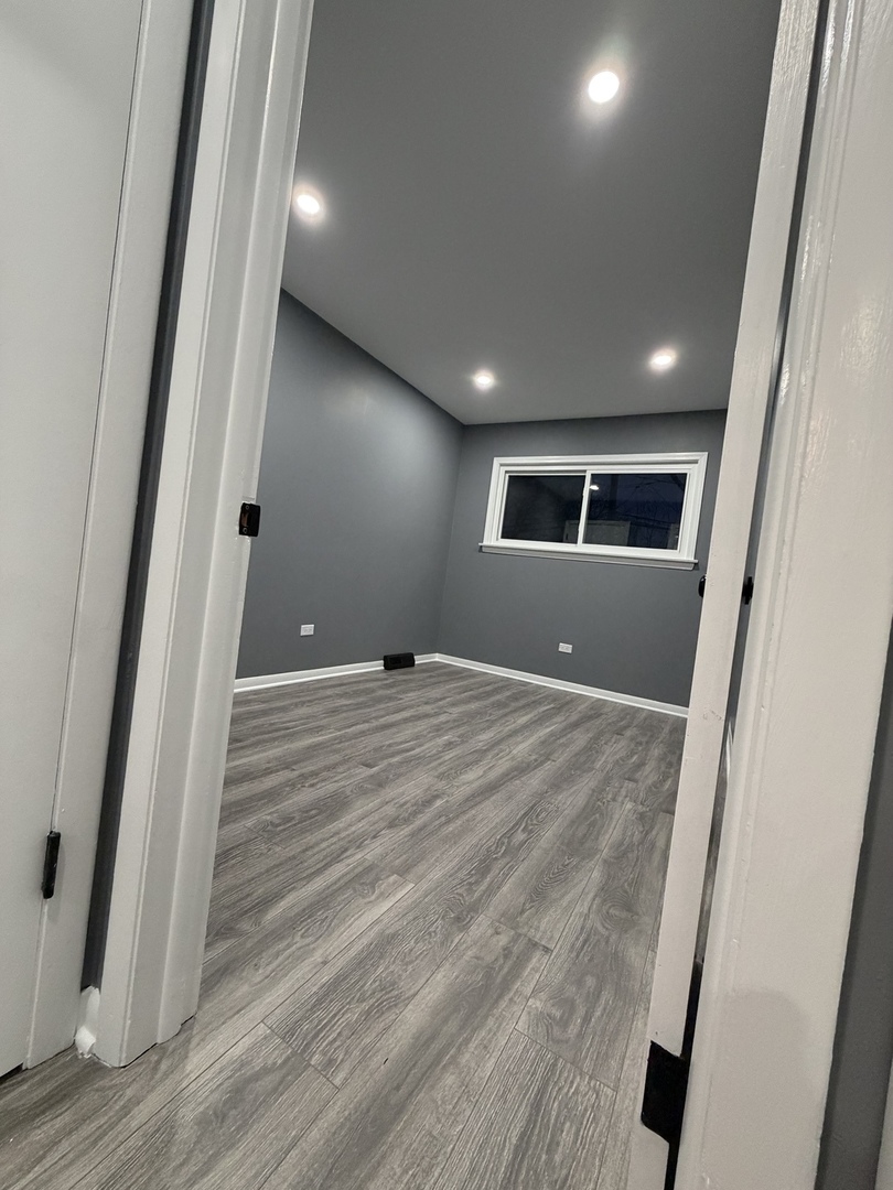 9534 South Yale Avenue Chicago, IL 60628 - Photo 24 of 26 a view of an empty room with wooden floor and a window
