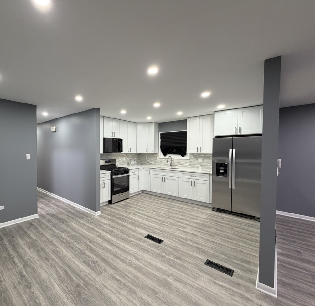 9534 South Yale Avenue Chicago, IL 60628 - Photo 5 of 26 a large kitchen with kitchen island a sink stainless steel appliances and cabinets