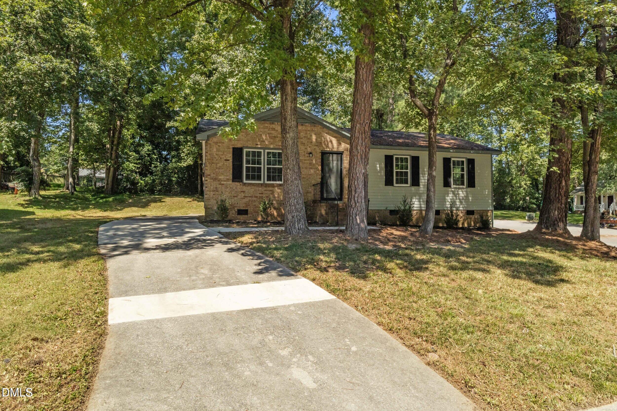 a view of a house with backyard and trees