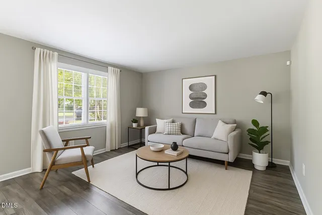 a living room with furniture a window and a potted plant
