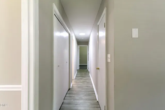 a view of a hallway with wooden floor