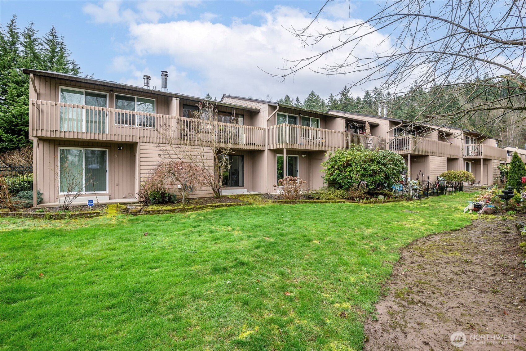 8521 South 259th Street, Unit B15 Kent, WA 98030 - Photo 1 of 24 a front view of a house with a yard and trees