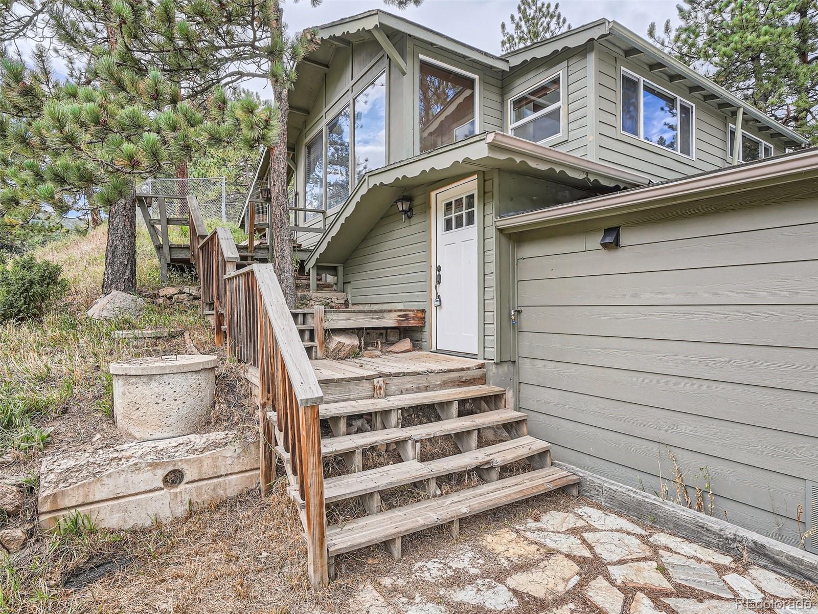 11799 Ranch Elsie Road Golden, CO 80403 - Photo 1 of 28 a front view of a house with a garden