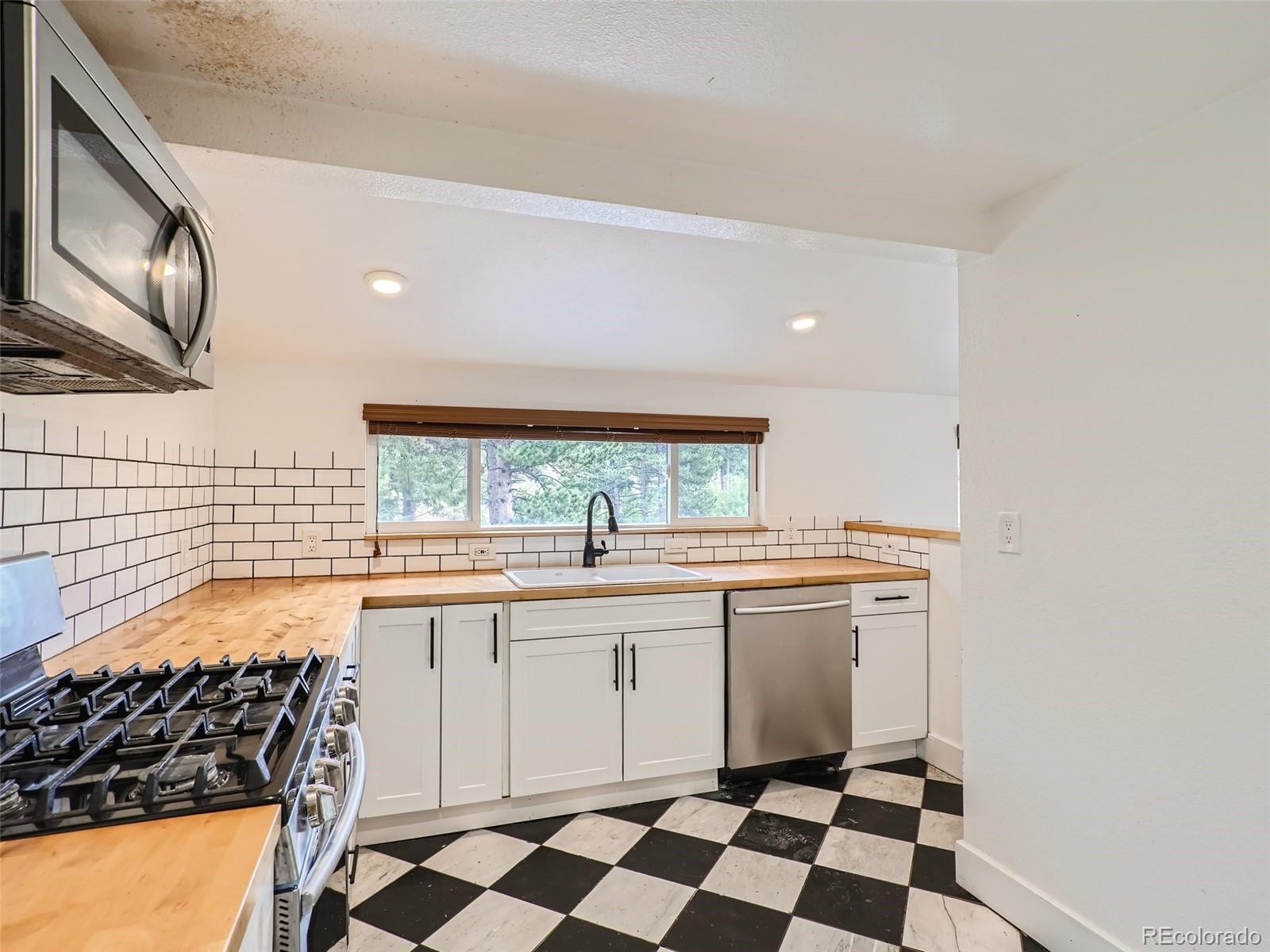 11799 Ranch Elsie Road Golden, CO 80403 - Photo 13 of 28 a kitchen with a stove a sink and a microwave