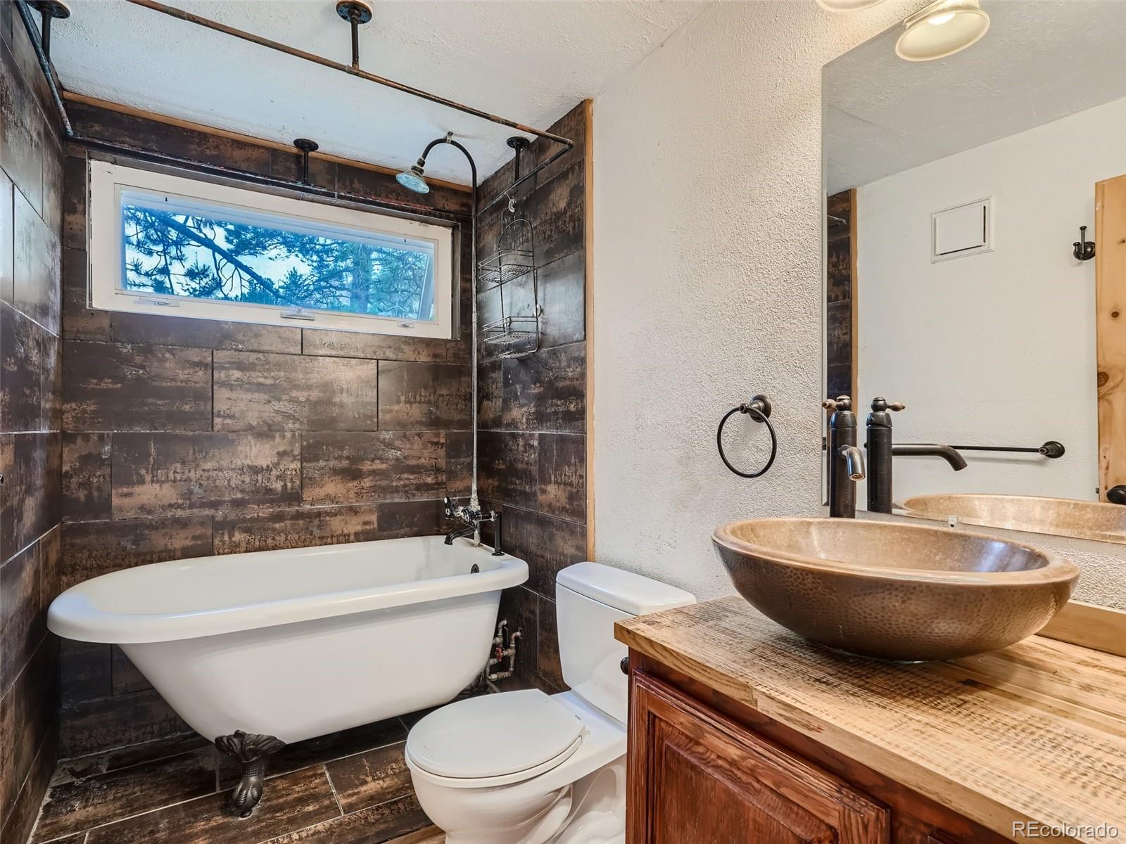 11799 Ranch Elsie Road Golden, CO 80403 - Photo 16 of 28 a bathroom with a granite countertop toilet a sink and bathtub