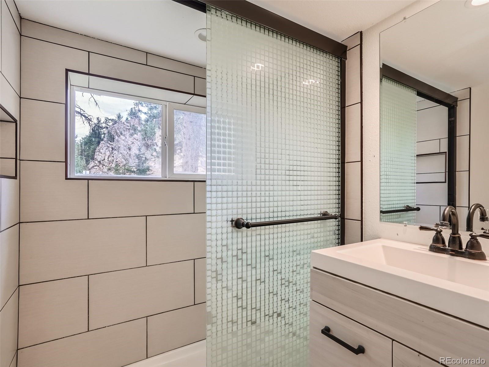 11799 Ranch Elsie Road Golden, CO 80403 - Photo 23 of 28 a bathroom with a sink and a large mirror