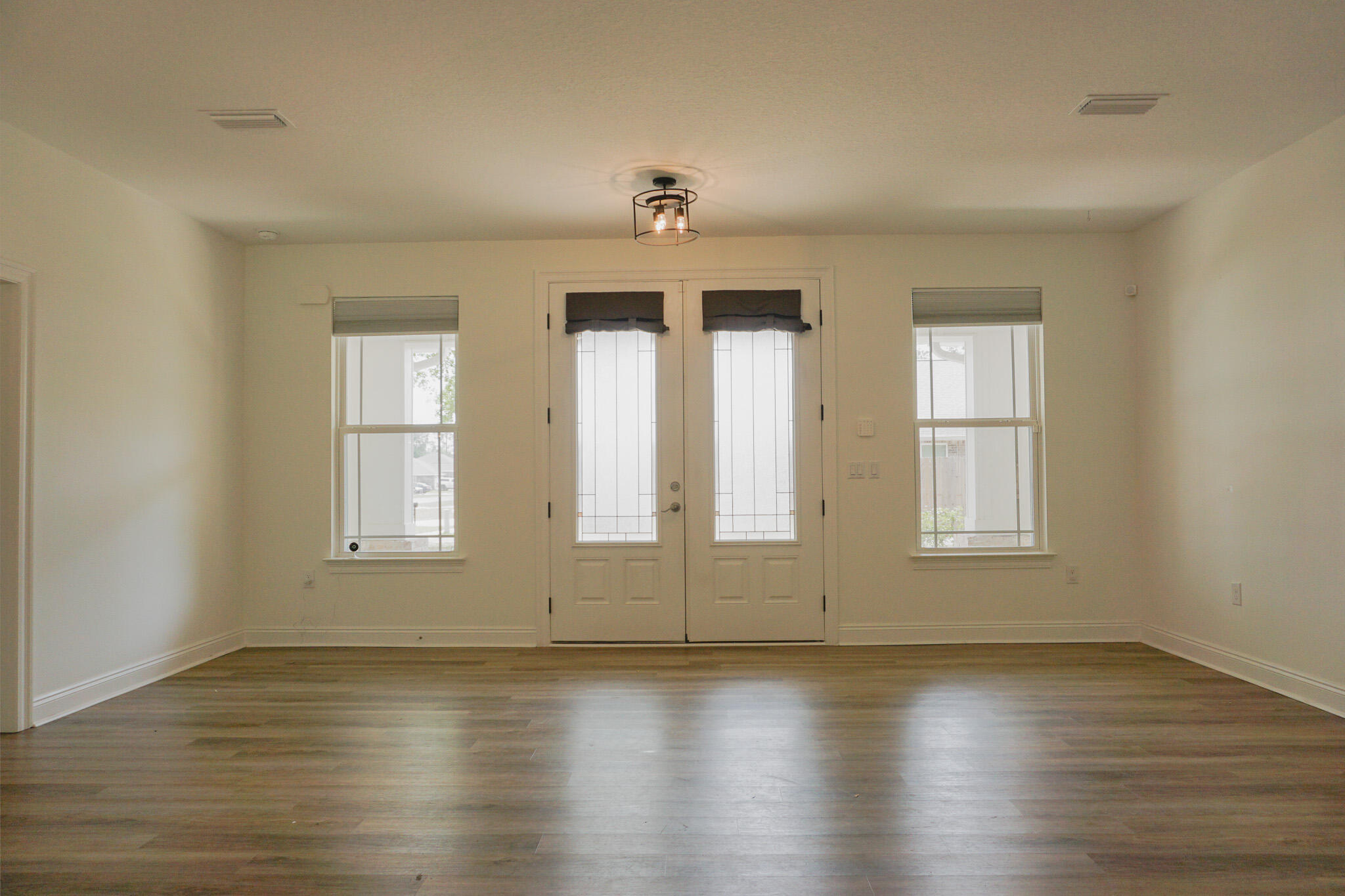 5464 Jenee Court Crestview, FL 32539 - Photo 10 of 63 an empty room with wooden floor and windows