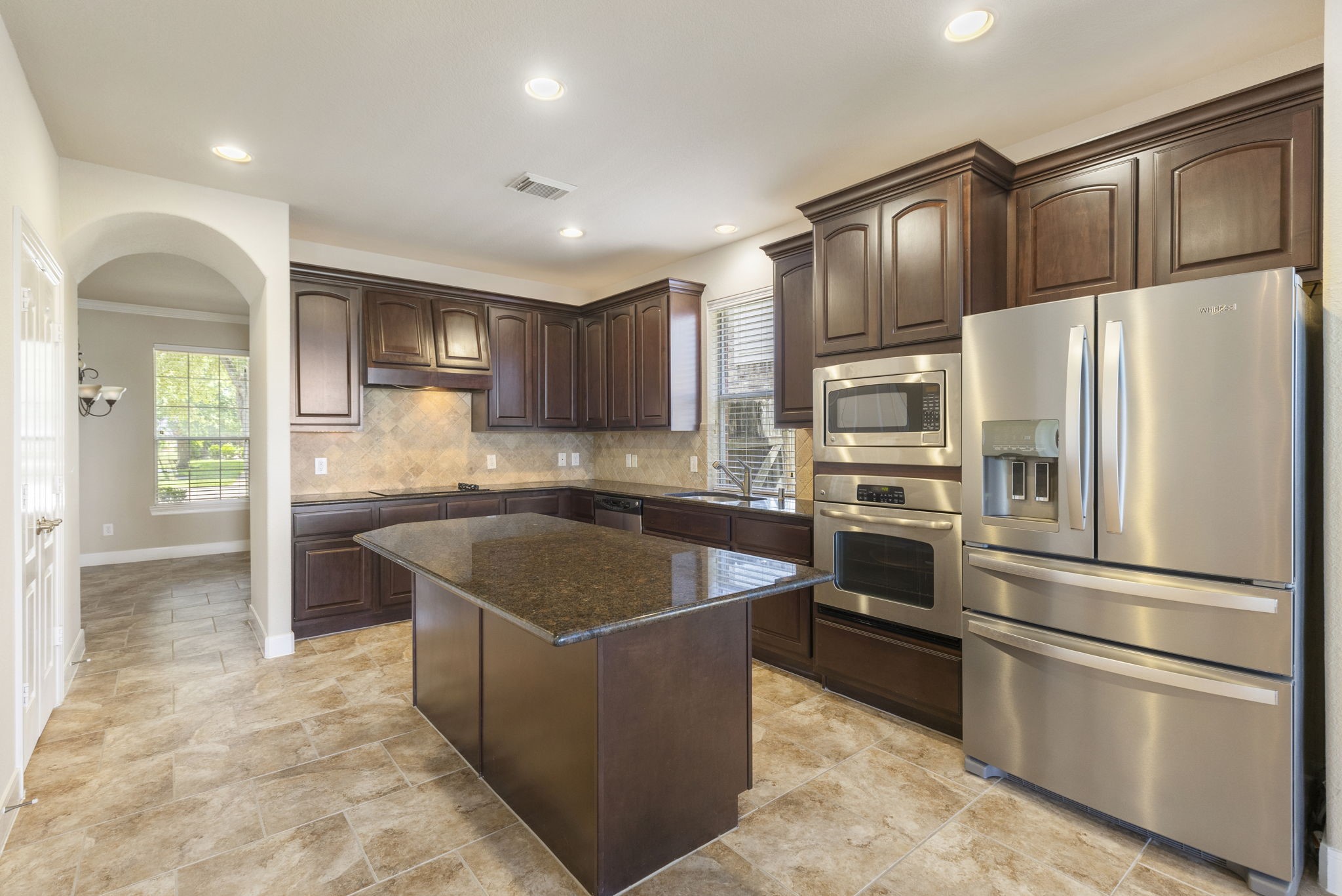 19222 Senterra Lakes Boulevard Spring, TX 77379 - Photo 9 of 45 This beautiful kitchen features rich dark wood cabinetry, expansive granite countertops, a large center island with seating space, and stainless steel appliances.