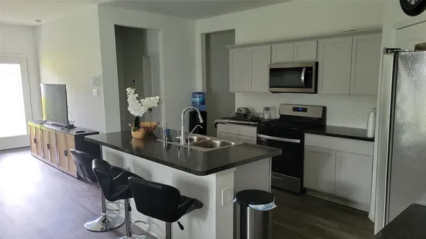 a kitchen with stainless steel appliances a sink and a refrigerator