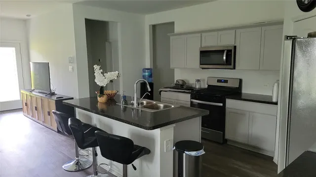 a kitchen with stainless steel appliances a sink and a refrigerator