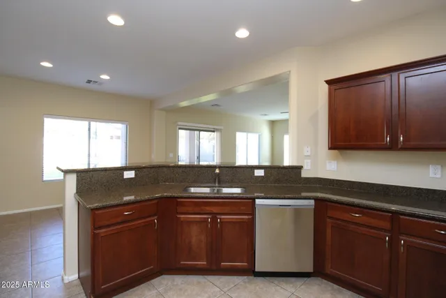 a kitchen with granite countertop a sink and cabinets