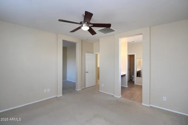 a view of a room with a ceiling fan and entryway