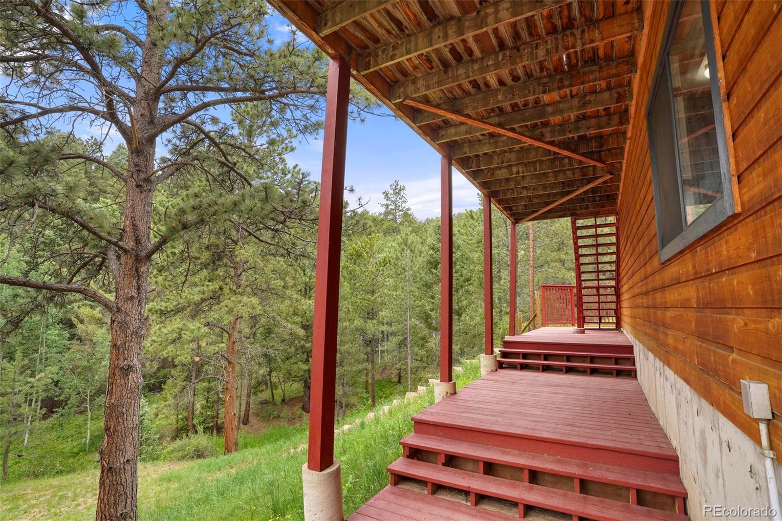 13519 Elsie Road Conifer, CO 80433 - Photo 21 of 31 a front view of a house with a yard table and chairs