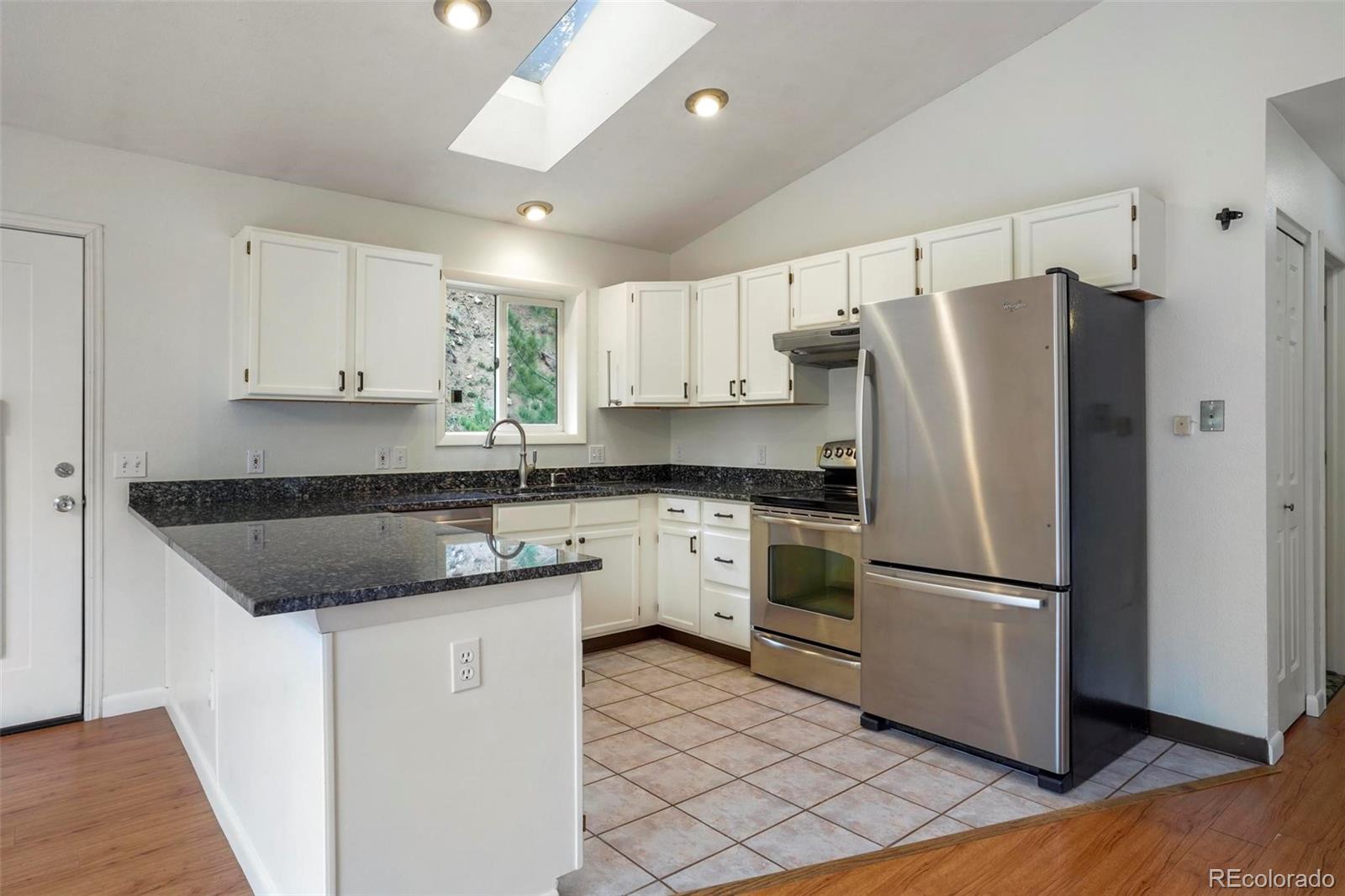 13519 Elsie Road Conifer, CO 80433 - Photo 6 of 31 a kitchen with a refrigerator sink and cabinets